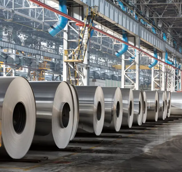 row of rolls of aluminum lie in production shop of plant.