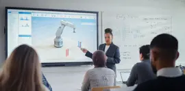 female professor standing next to interactive whiteboard and teaching diverse students innovations in robotics. computer science and modern technologies in higher education concept.